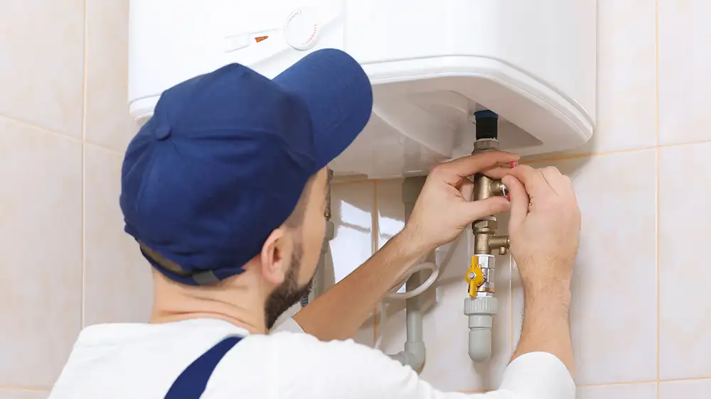 Klempner installiert Warmwasserbereiter im Badezimmer